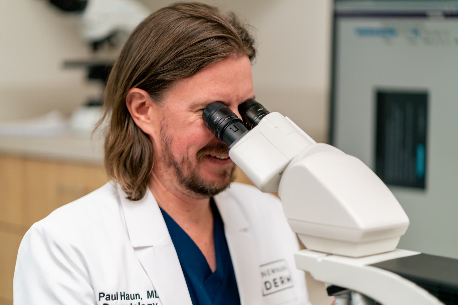 Paul Haun, MD reading pathology slides at the microscope in our practice's dermatopathology lab